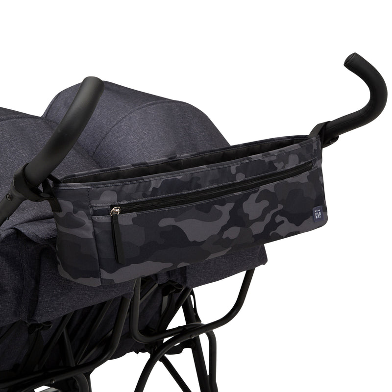 Stroller with a dark blue camouflage bag attached to the handle on a white background