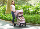 Woman pushing a pink stroller with a child in a park 8-babyGap 2-in-1 Carriage Stroller
