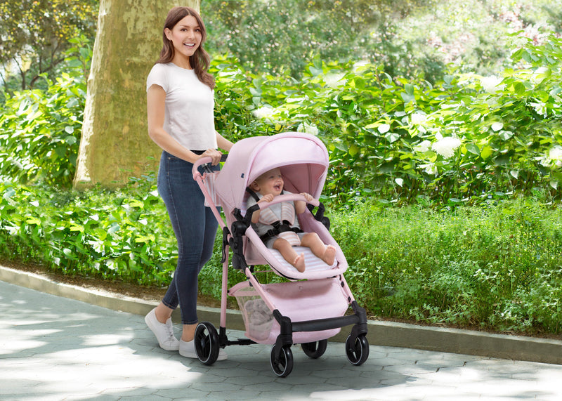 Woman pushing a pink stroller with a child in a park 8-babyGap 2-in-1 Carriage Stroller