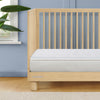 Wooden crib with a white mattress against a blue wall 15-Breeze Breathable Crib Mattress Topper