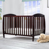Wooden crib in a bright room with a teddy bear on the floor. 14-Taylor 4-in-1 Convertible Crib