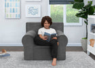 Child sitting in a gray chair reading a book in a room with a window and plant. 13-XL Cozee Foam Chair - Perfect Size for Kids Ages 18 Months - 12 Years+