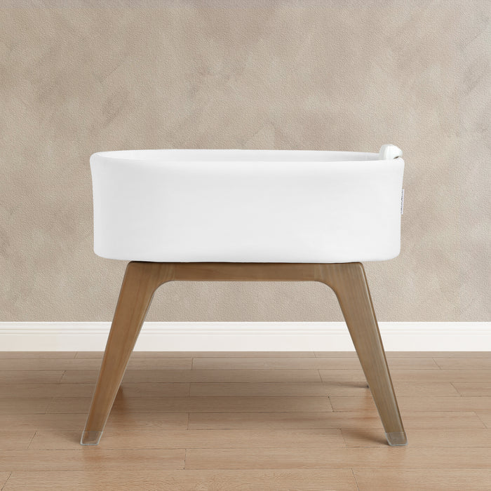White cushioned stool with wooden legs on a beige wall and wooden floor background 0-Aero Smart Auto Glide Bassinet with Cry Detection & Bluetooth Wireless Technology