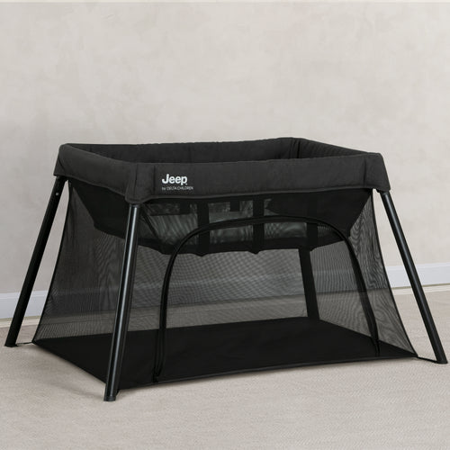 Black Jeep travel cot on a light gray background