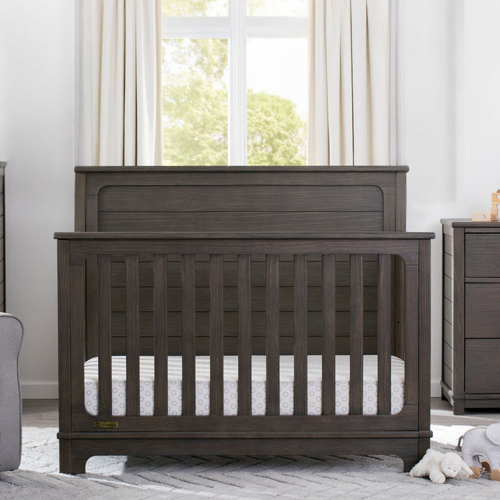 Wooden crib in a nursery with a dresser and window in the background 0-Monterey Crib 'N' More