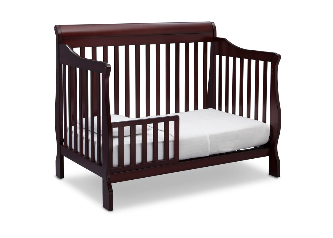 Wooden crib with a white mattress on a white background