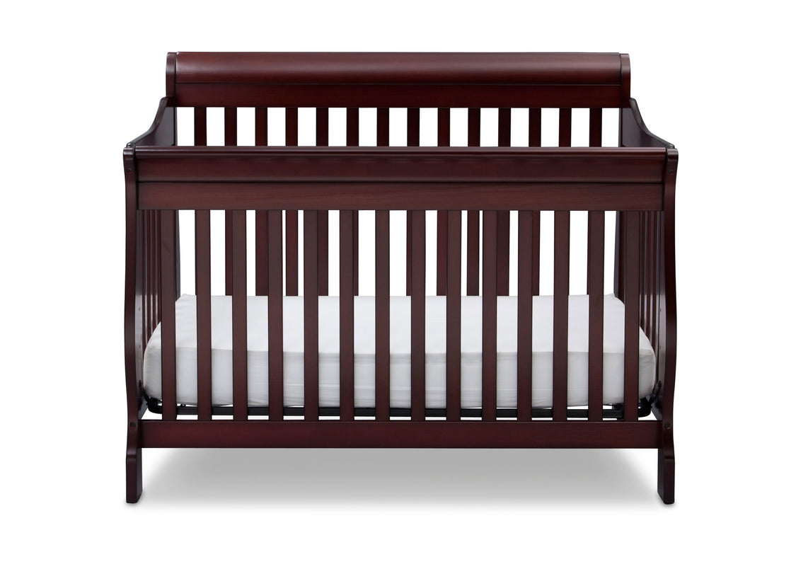 Dark wood crib with white mattress on a white background