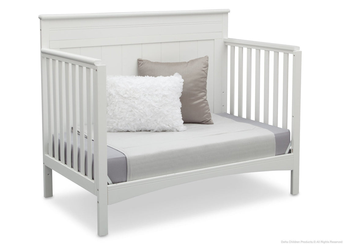 White crib with gray bedding and pillows on a white background