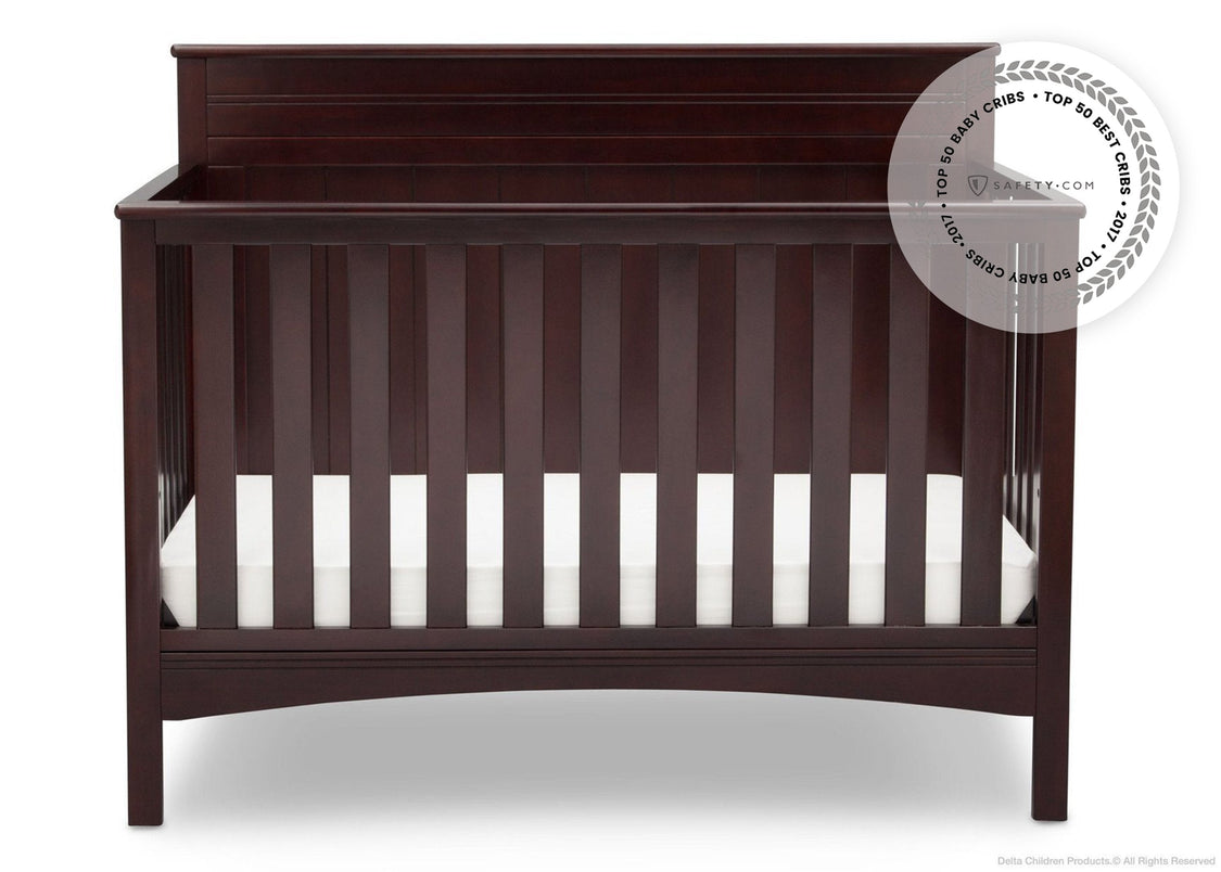 Dark wood crib with white mattress on a white background