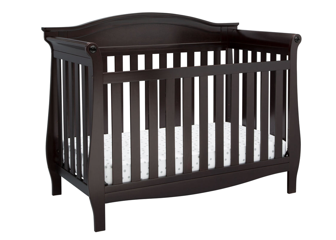Dark wood crib with white mattress on a white background