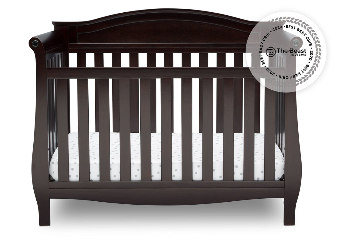 Dark wood crib with white mattress on a white background