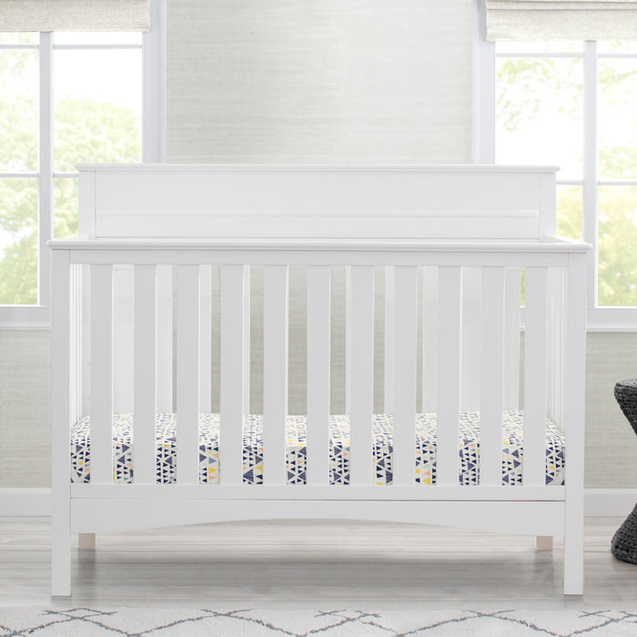 White crib in a room with large windows and a rug. 1-Skylar 6-in-1 Convertible Crib