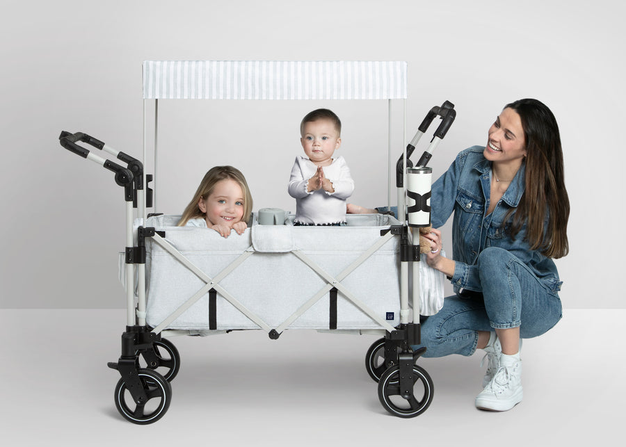 Woman with two children inside a white folding cart on a light gray background 10-babyGap Explorer Deluxe Stroller Wagon