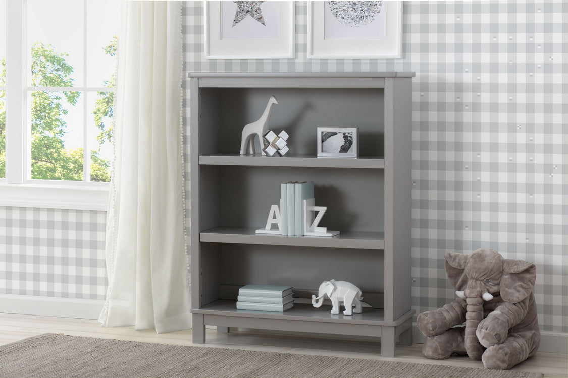 Gray bookshelf with decorative items in a room with checkered wallpaper and a window.