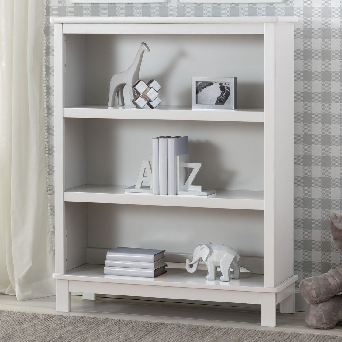 White bookshelf with decorative items against a neutral wall