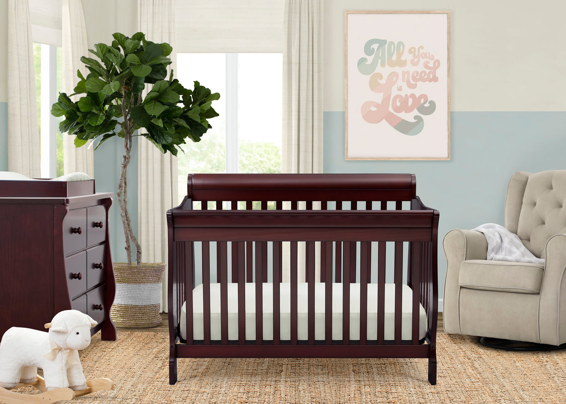 Nursery room with a wooden crib, dresser, and armchair.