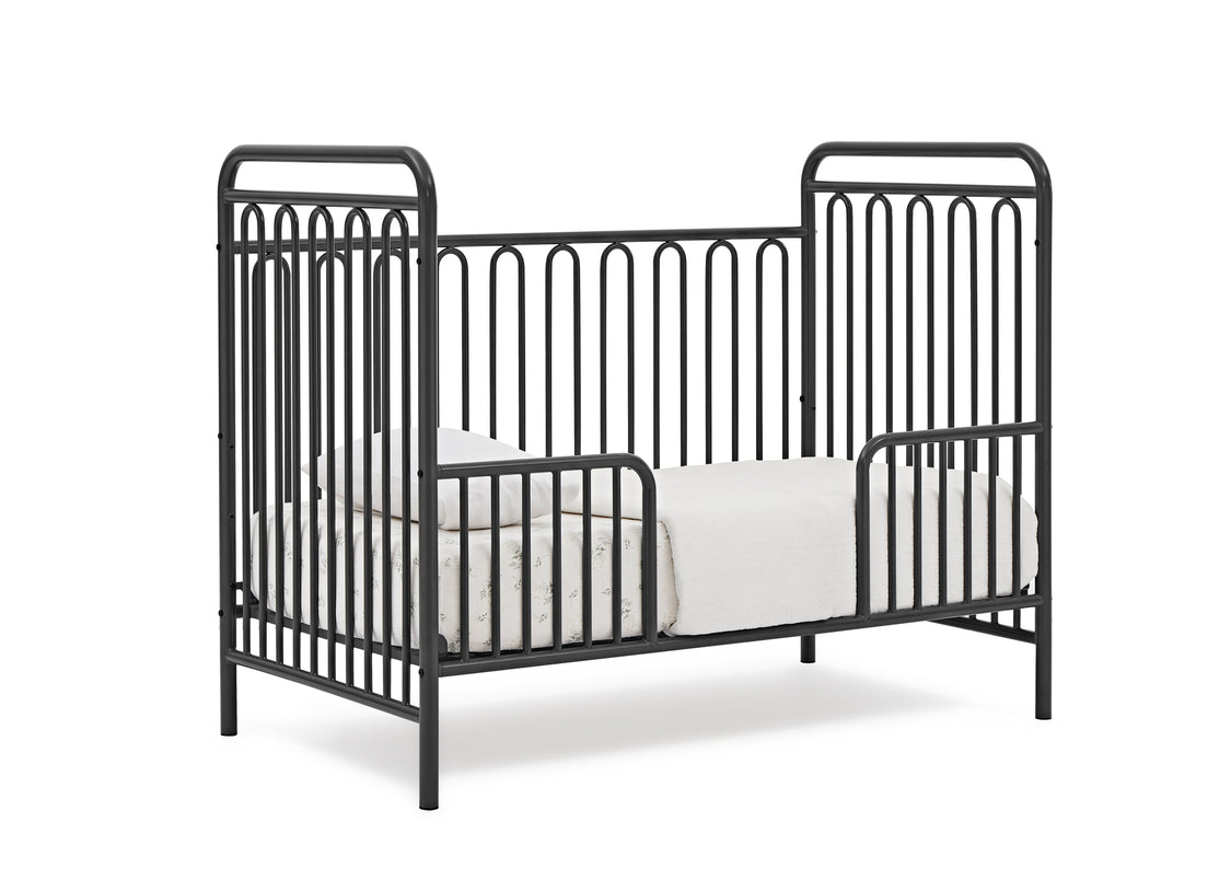Black metal crib with white mattress on a white background