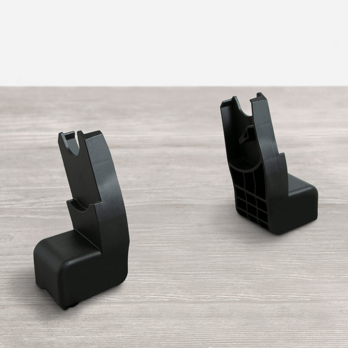 Two black car seat adapters on a grey surface, designed to connect a car seat to a stroller. 2-Clek Liing Car Seat Adapter (fits Strollers 11110, 12900, 60001 & 60003)