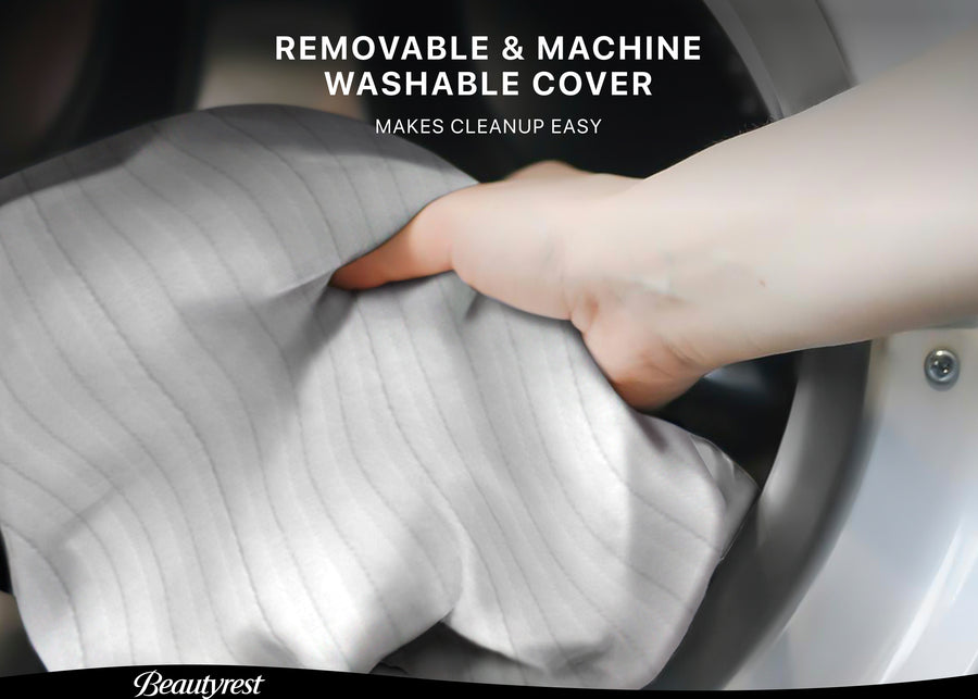Hand lifting a white cover from a mattress with text about a removable and machine-washable cover. 3-Beautyrest Black BreatheCool 2-Stage Crib and Toddler Mattress