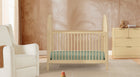 Nursery room with wooden crib, chair, and dresser. 1-Cannon Collection