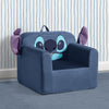 A blue plush children's armchair designed to look like a cartoon character face, with large light blue eyes, a dark nose, and purple ears, set against a striped wallpaper background. 8-Lilo & Stitch Cozee Kids Chair