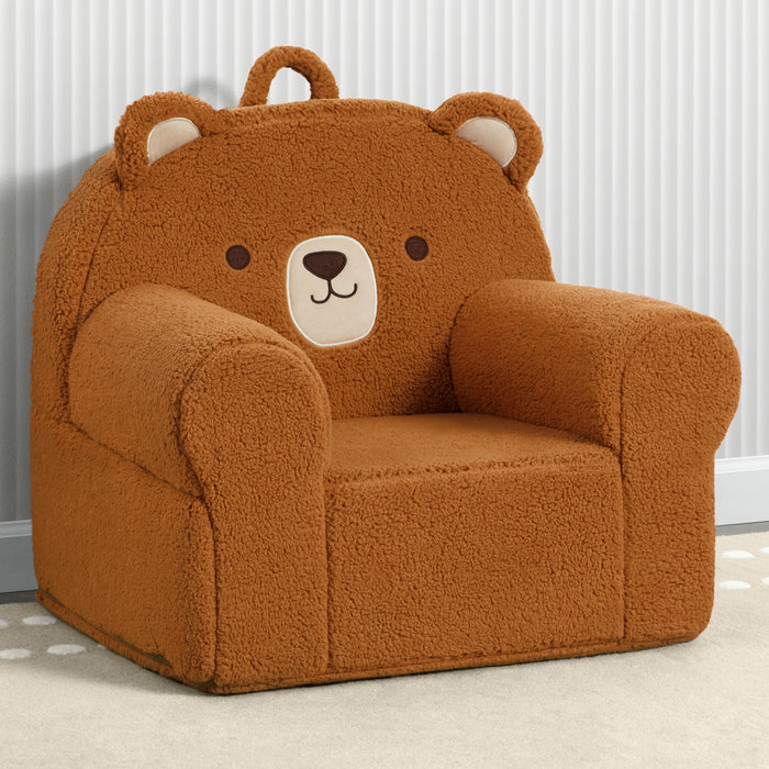 A plush brown teddy bear chair with a handle, designed for children, with a slipcover featuring a bear face. 3-Deluxe Cozee Teddy Bear Chair