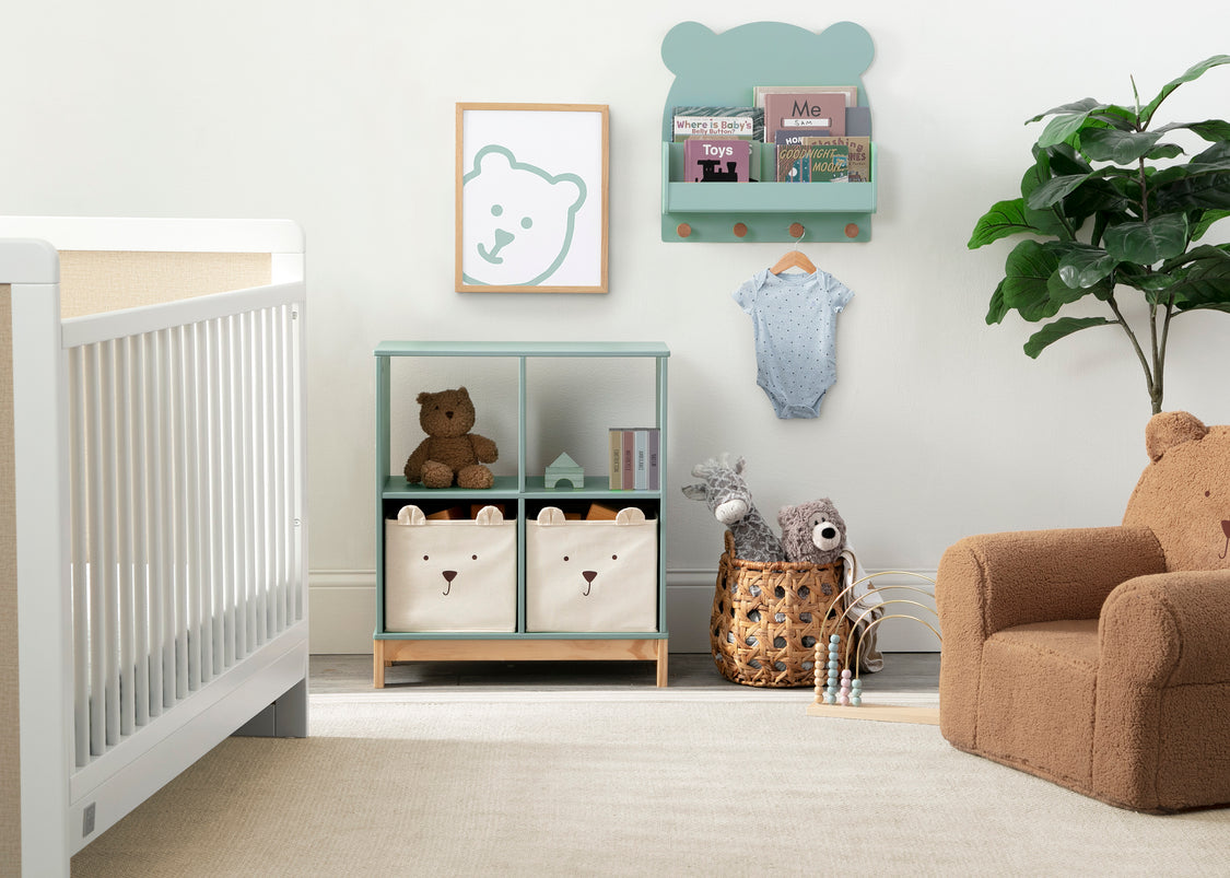 Nursery room with white crib, bookshelf, and armchair.