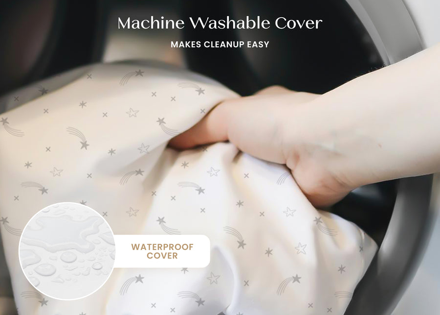 Hand holding a machine washable cover with text indicating it makes cleanup easy and is waterproof. 18-Refresh 2-Stage Crib and Toddler Mattress