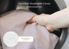 Hand holding a machine washable cover with text indicating it makes cleanup easy and is waterproof. 40-Refresh 2-Stage Crib and Toddler Mattress