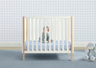 Child in a crib with a checkered wall and gray toy elephant on a blue carpet 13-Simmons Kids® Soothing Nights 3-inch Mini/Portable Crib Mattress