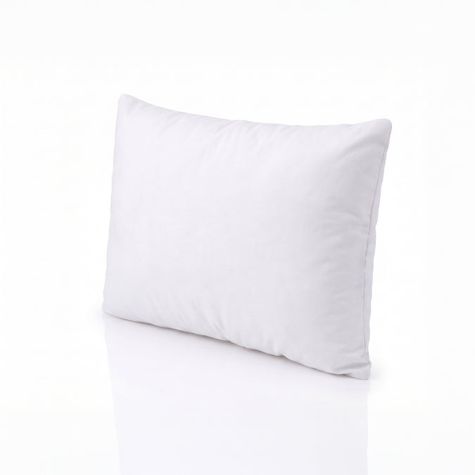A plain white rectangular pillow or cushion shown at an angle on a clean white studio background with a soft reflection below. 28-Beautyrest Cooling Toddler Pillow