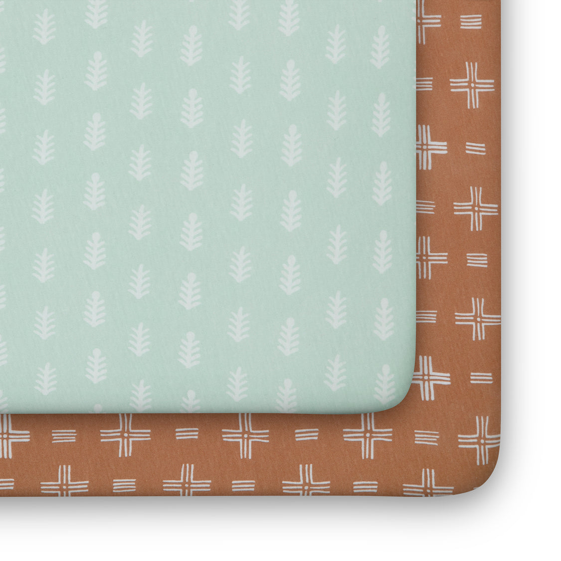 Two patterned boards, one green with white leaf design and one brown with white line design, on a light gray background.