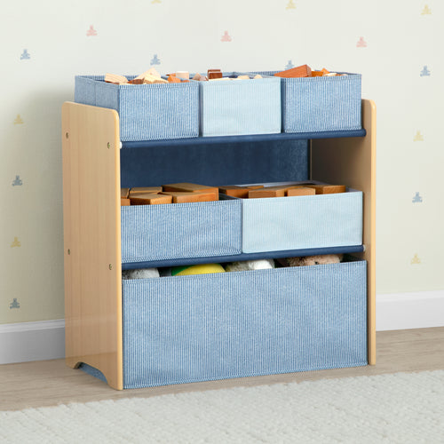 Toy storage unit with blue bins and wooden toys against a light-colored wall.