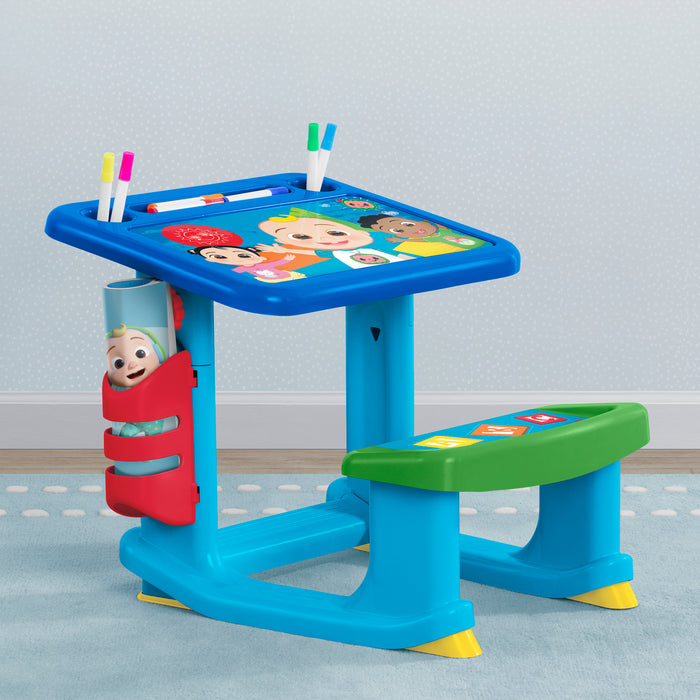 Children's desk with colorful design and accessories on a light gray floor. 1-CoComelon Draw and Play Desk