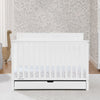 White crib with a floral patterned wall in the background 60-Logan 6-in-1 Convertible Crib with Underdrawer
