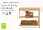 Wooden changing table with teddy bear and baskets on a white background, featuring safety certification logos. 72-Scout Changing Table