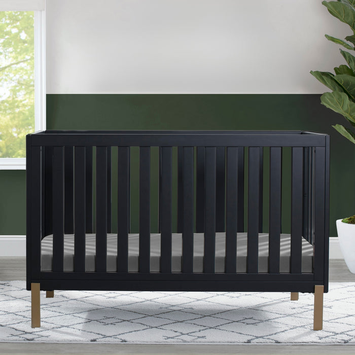 Black crib in a room with green walls and a plant 2-Hendrix 4-in-1 Convertible Crib