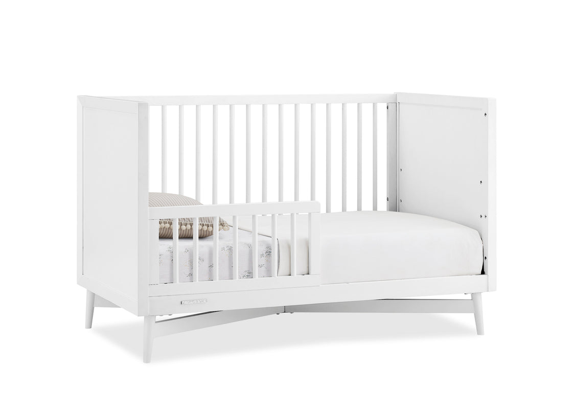 White crib with mattress on a white background
