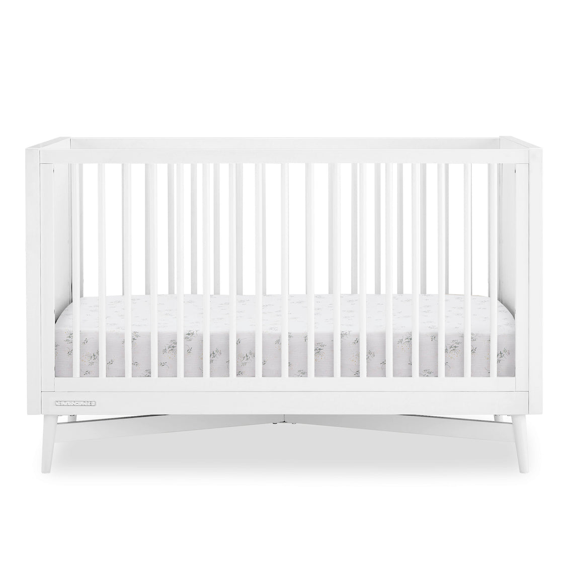 White crib with a white mattress on a white background