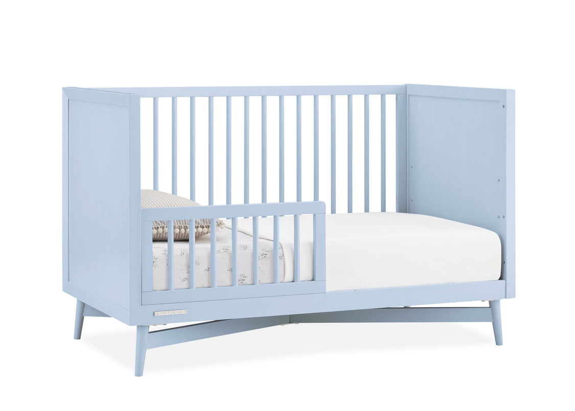 Light blue crib with white mattress on a white background