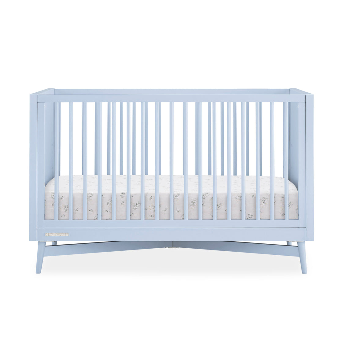 Light blue crib with white mattress on a white background