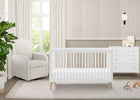 Nursery room with a white crib, armchair, and dresser. 17-Jordan 4-in-1 Convertible Crib