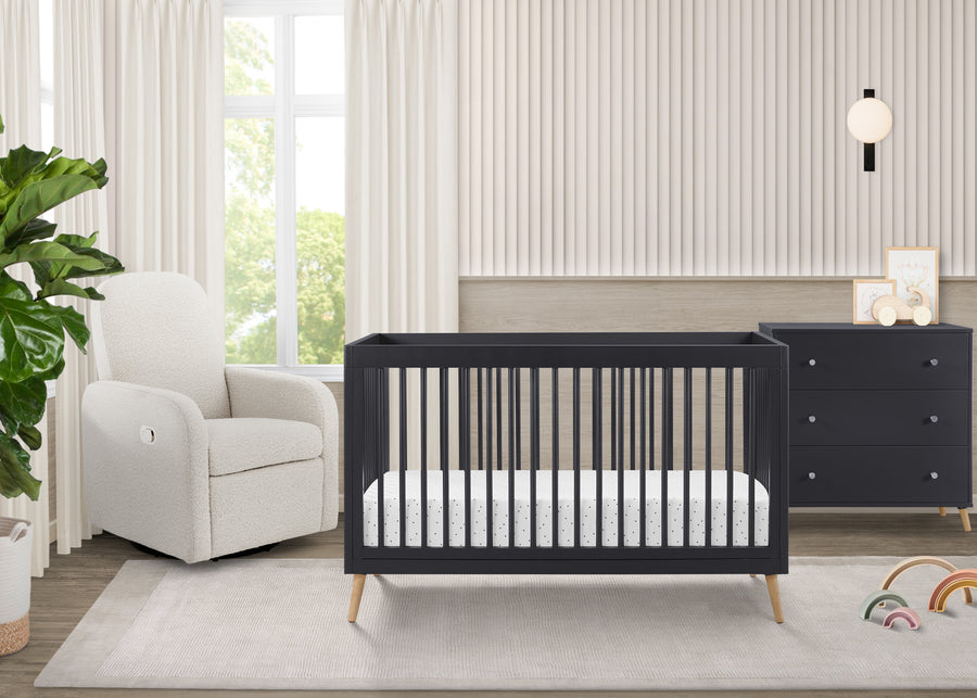 Nursery room with a black crib and white armchair near a window. 16-Jordan 4-in-1 Convertible Crib