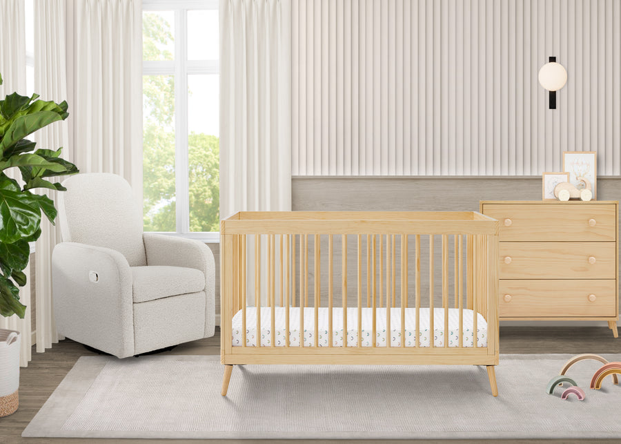 Nursery room with a wooden crib, white chair, and dresser. 48-Jordan 4-in-1 Convertible Crib