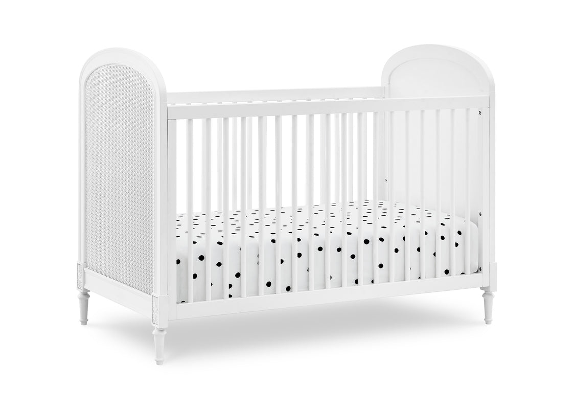 White crib with a polka dot mattress on a white background