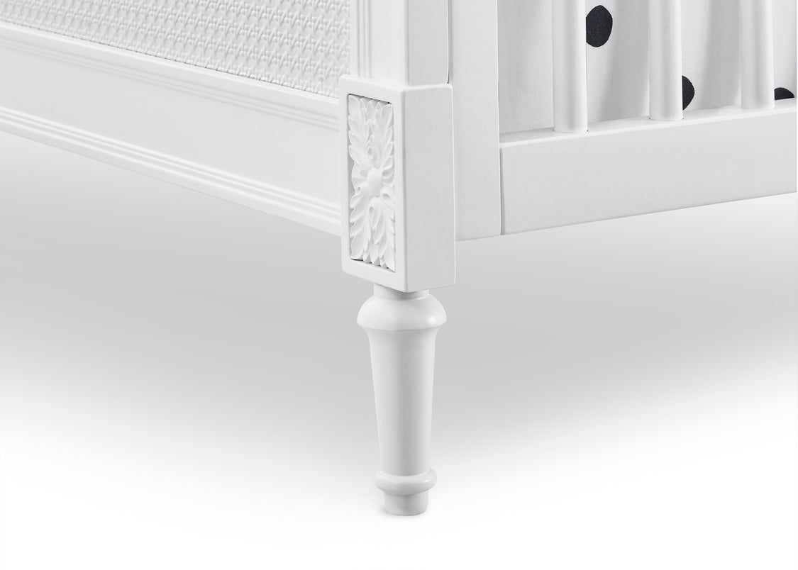 Close-up of a white crib with decorative elements on a white background