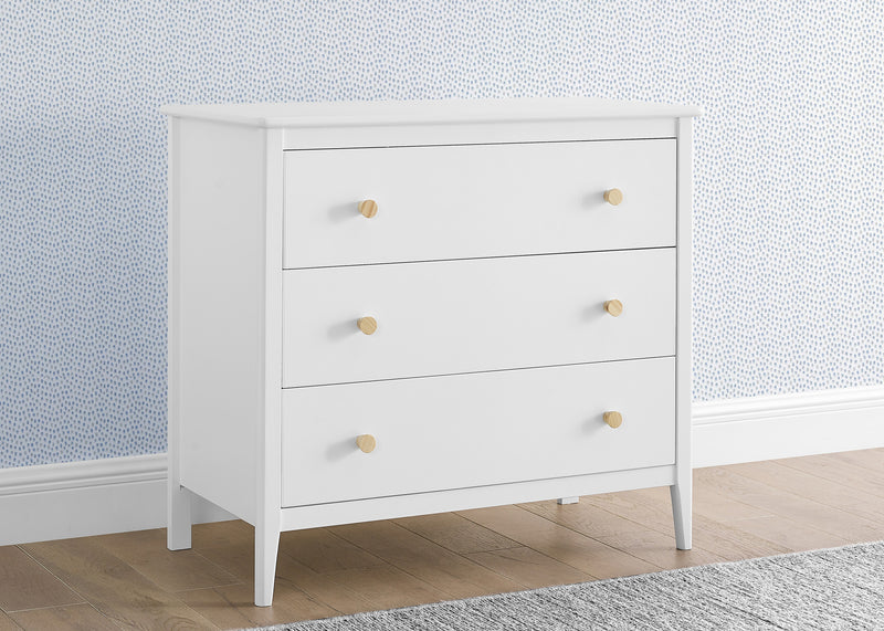White dresser with three drawers against a light blue wall. 11-Casey 3 Drawer Dresser with Interlocking Drawers