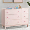 Pink dresser with colorful decor items against a light gray wall. 10-babyGap Legacy 6 Drawer Dresser with Interlocking Drawers