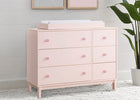 Pink dresser with changing pad in a room with framed pictures and a plant. 11-babyGap Legacy 6 Drawer Dresser with Interlocking Drawers