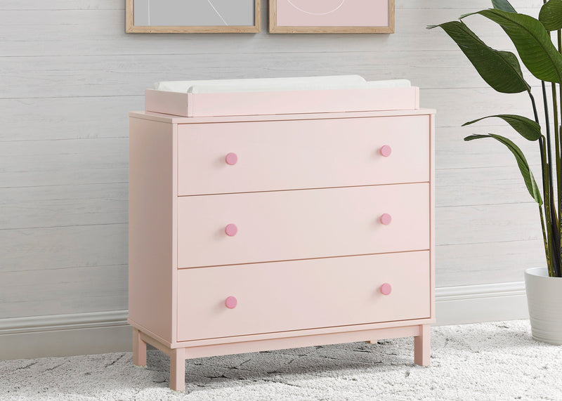 Pink dresser with changing table top in a room setting